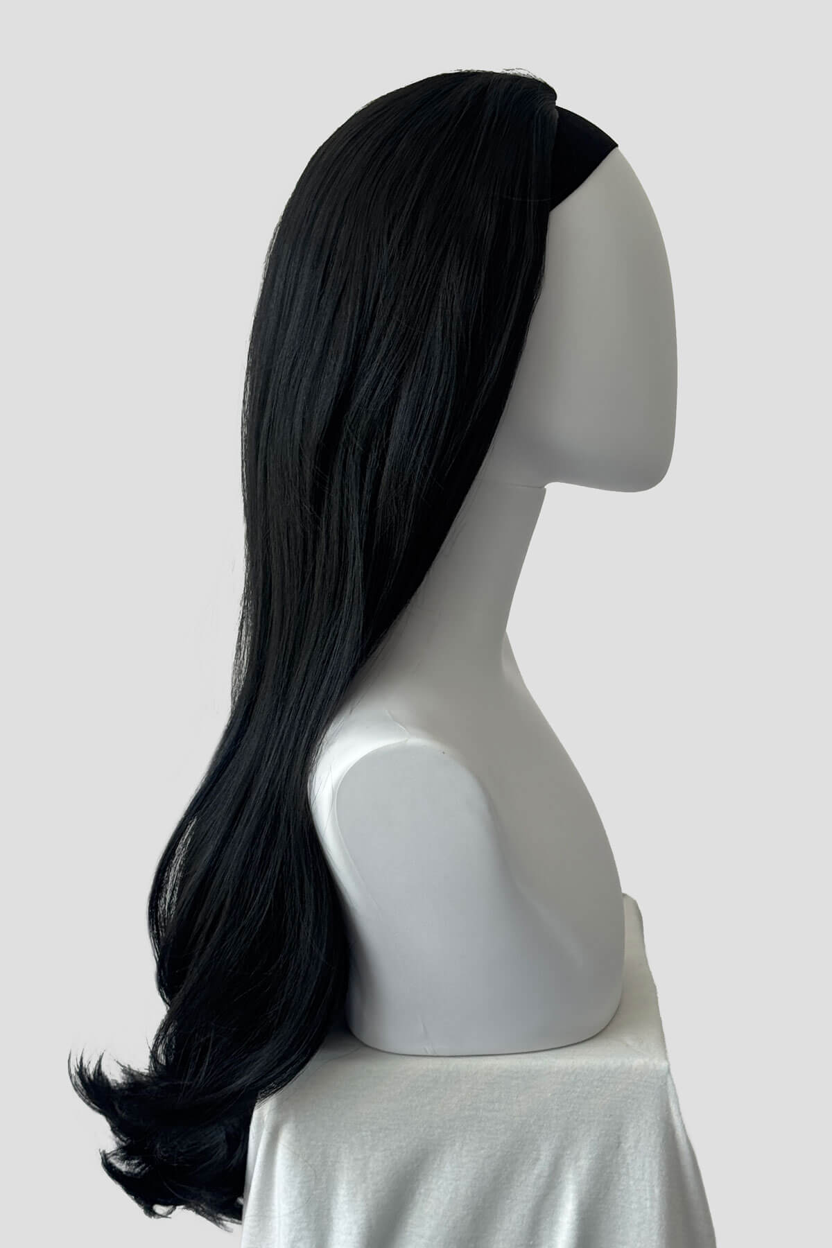 Long, black wig on a plain background. Kate - Heat Styleable Extra Long, Gentle Wave Half Wig black 1B