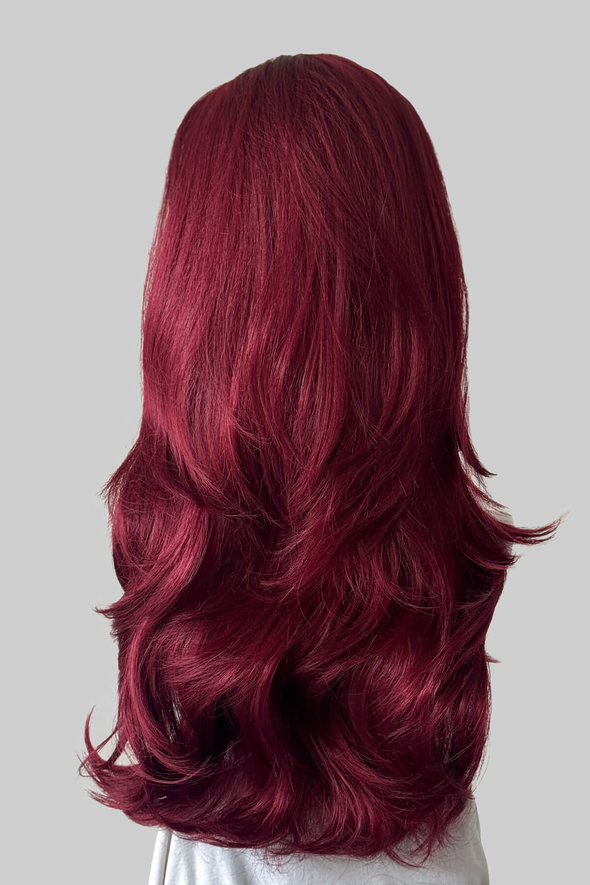 Long, wavy burgundy red half wig, shown from the back against a solid grey background.  Claudia - Volume Boosting Long Gentle Bouncy Layered Half wig dark cherry red 39
