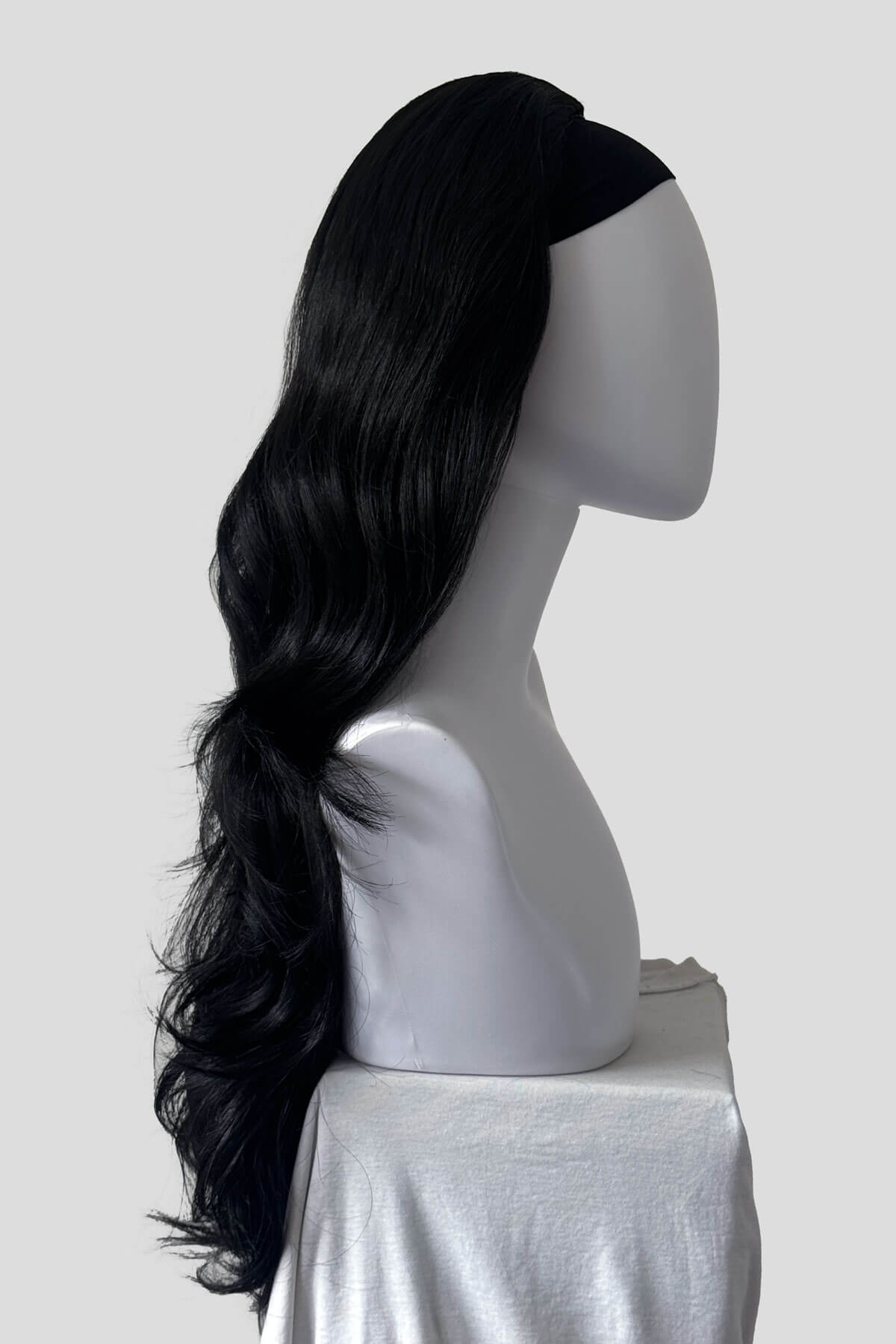 A long, straight black wig with soft waves and a side-swept bang, displayed on a white mannequin head and shoulders against a light background. Half wig with volume booster/height booster: Corrine black 1B