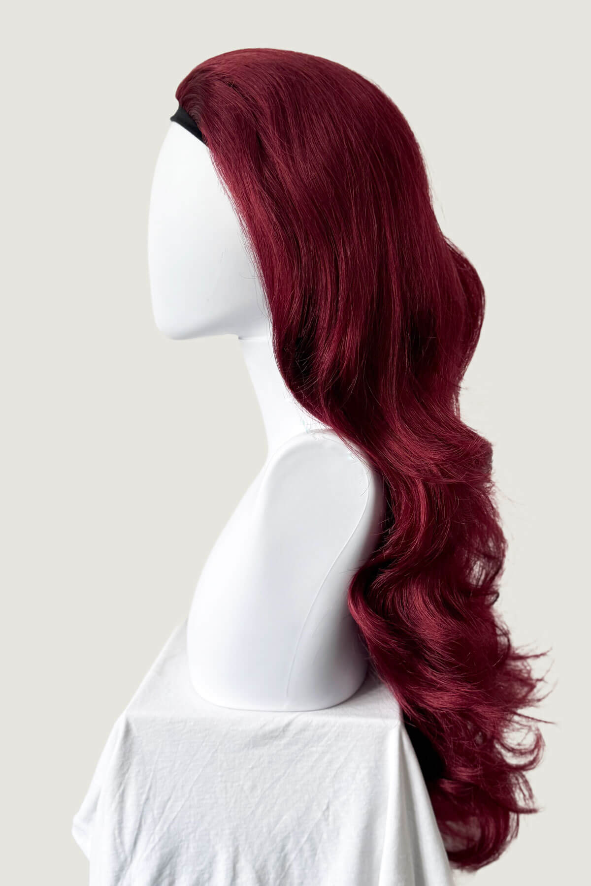 Red wig on a mannequin head against a white background. Red half wig (3/4 hairpiece) with long waves: Sasha wine red 39