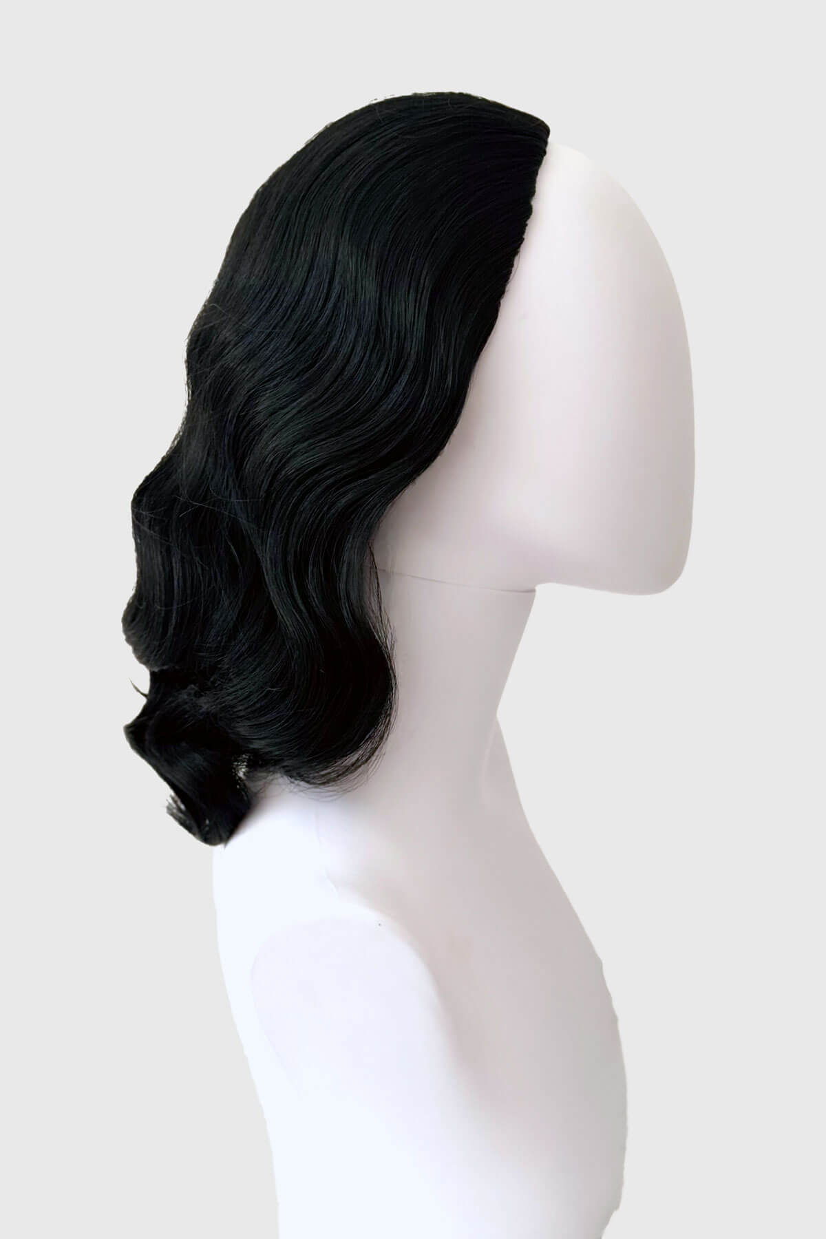 Black wig on a mannequin head against a white background. 1940s style half wig hairpiece with beautiful marcel waves: Virginia jet black 1