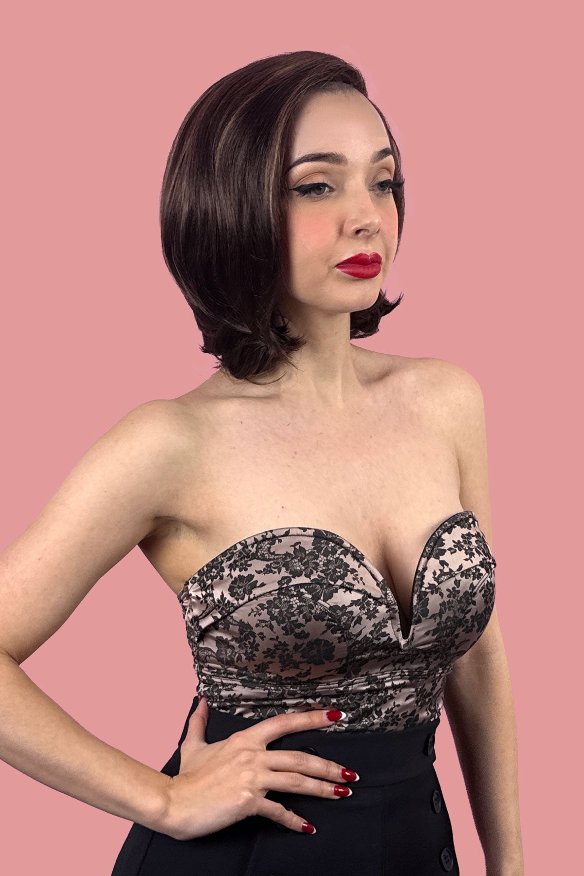 Woman wearing a strapless top with lace details against a pink background. Brown Lace Front Bob Wig with Blonde Highlights - Italian Bob Style: Lucia