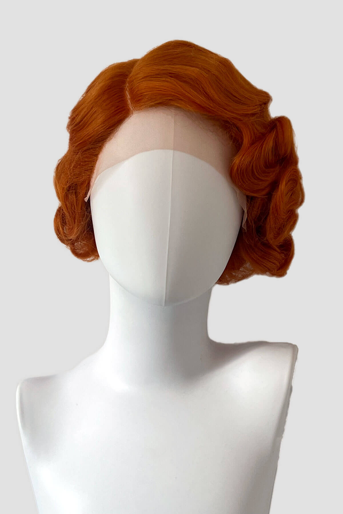 Red wig on a mannequin head against a white background. Ginger pinup wig, lace front, vintage style: Flo