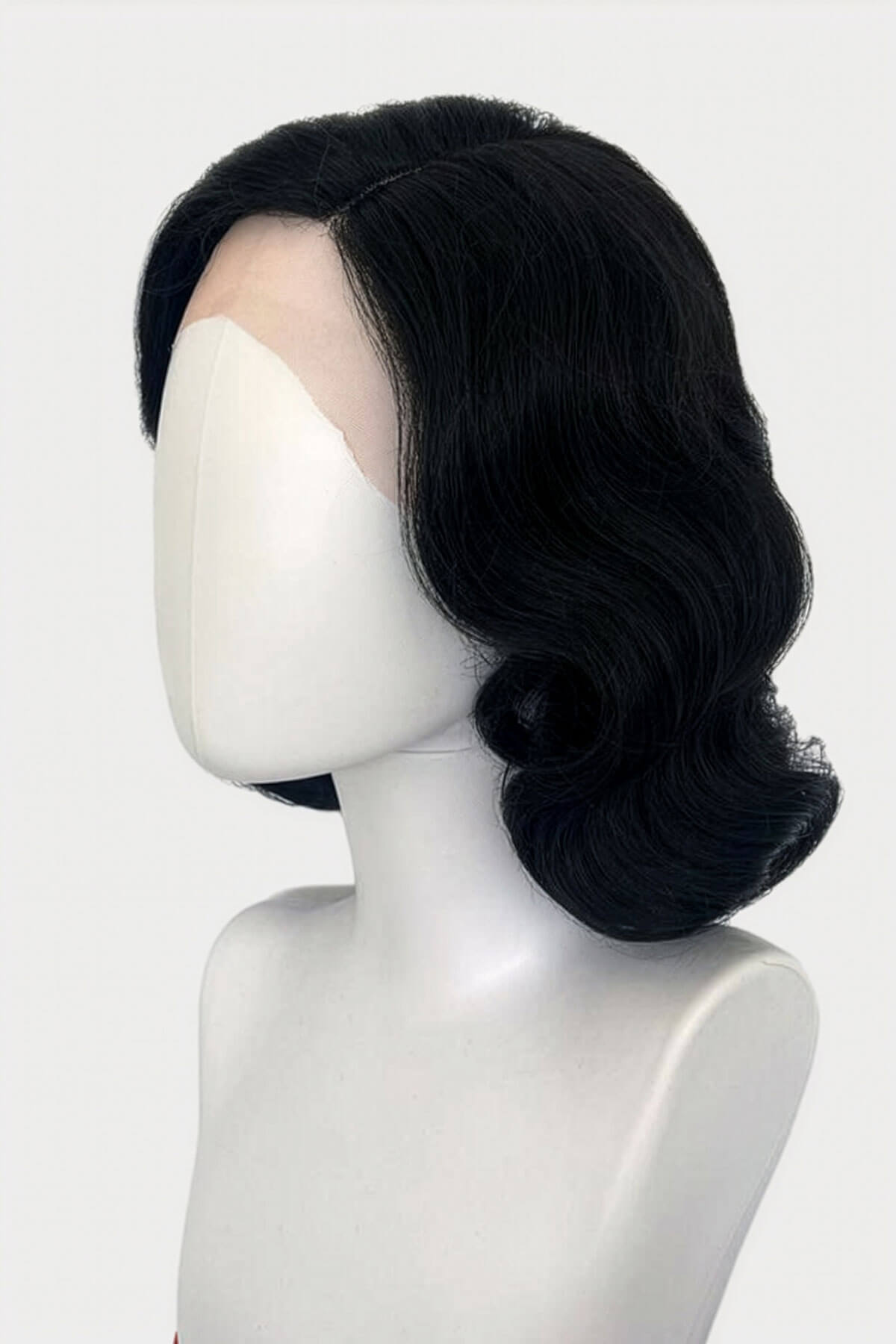 Black wig on a mannequin head against a white background pictured from the side. Black lacefront wig, pinup/vintage style, mid length with finger waves: Lilith black 1B gothic 
