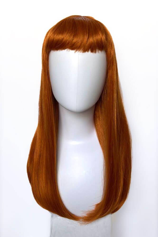 Reddish-brown wig on a white mannequin head against a white background. Long ginger wig with straight hair and a short, straight fringe: Daphne