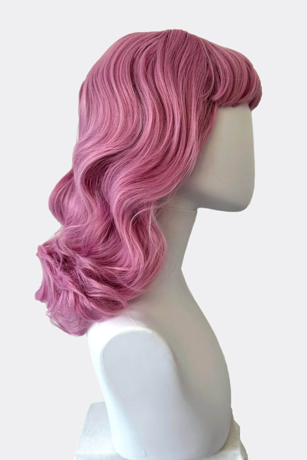 Pink wig on a mannequin head against a white background. Pink pinup style wig, with finger waves and a short fringe, 1950s style: Stevie light pink 2614