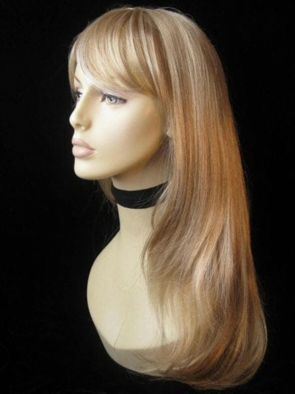 Blonde wig on a mannequin head against a black background. Long blonde wig, face framing with long, side-sweeping fringe: Ashley