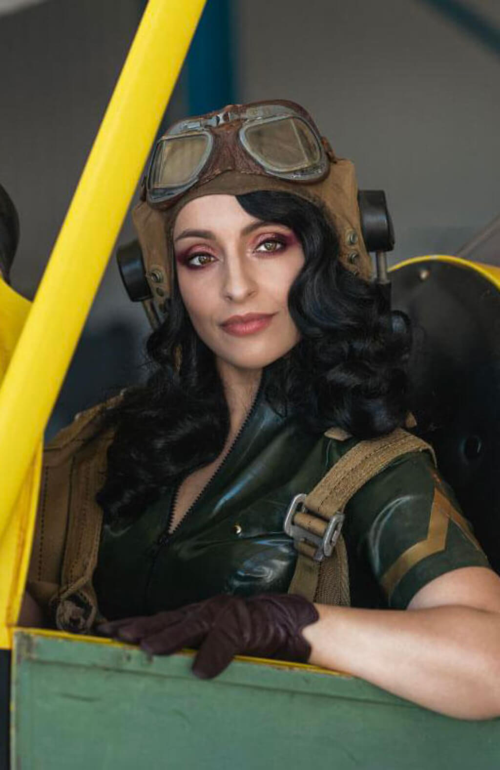 Person in vintage pilot costume with goggles.  Black 1940s style wig with long marcel waves: Vivienne